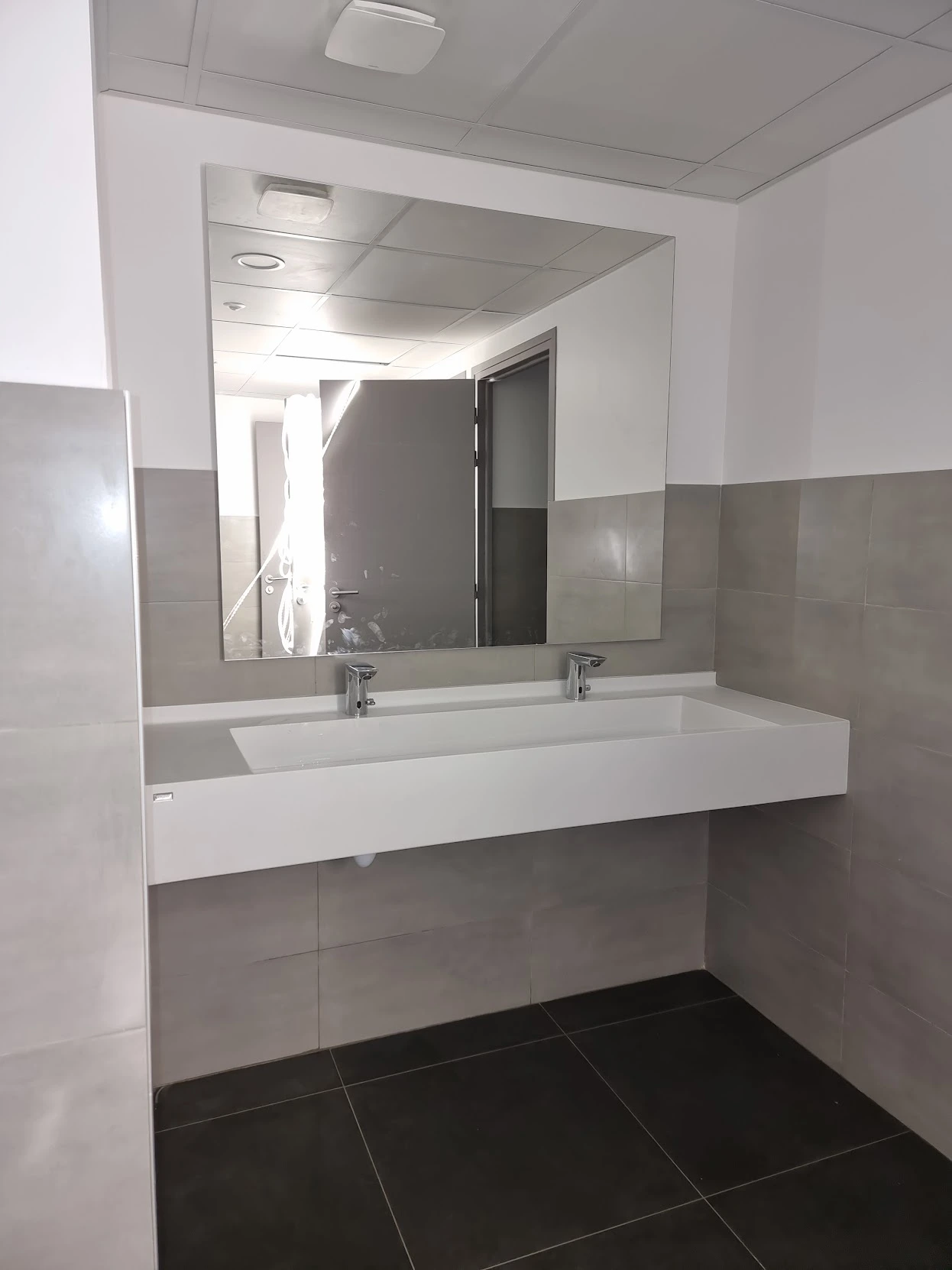 Plan vasque à deux robinets et grand miroir